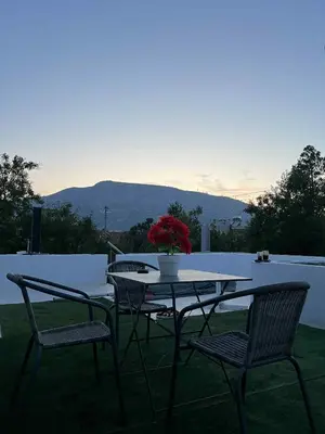 a table with two chairs and a vase with flowers on it at Minimal Above in Paianía
