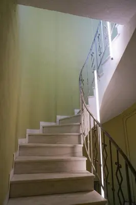 a stairway with white stairs and a green wall at The Saints Inn in Athens
