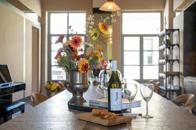 a table with a vase of flowers and wine glasses at The Saints Inn in Athens