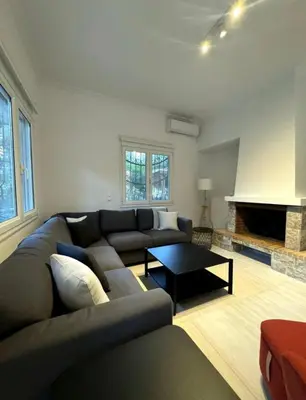 a living room with a couch and a table at Modern Glyfada Apartment Sleeps 6, 5min Walk to Beach in Athens