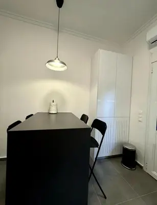 a room with a table with chairs and a light at Modern Glyfada Apartment Sleeps 6, 5min Walk to Beach in Athens