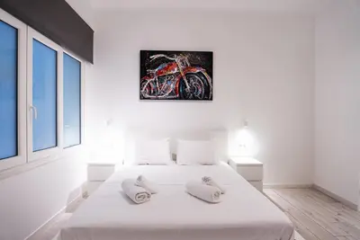 a white bedroom with a white bed with two pillows at Syntagma square 25sqm Cozy studio in Athens