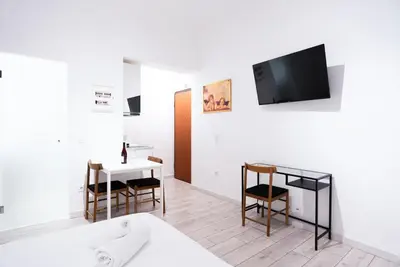 a living room with a bed and a table and a tv at Syntagma square 25sqm Cozy studio in Athens