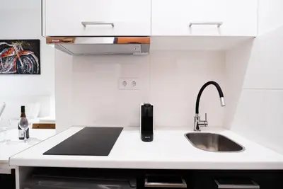 a kitchen with white cabinets and a sink and a counter at Syntagma square 25sqm Cozy studio in Athens