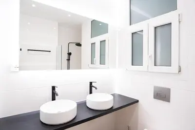 a white bathroom with two sinks and mirrors at Syntagma square 25sqm Cozy studio in Athens