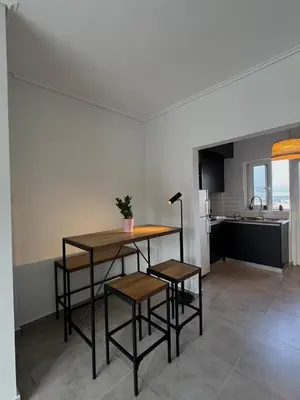 a kitchen with a table and two stools in a room at Captain's flat in Piraeus