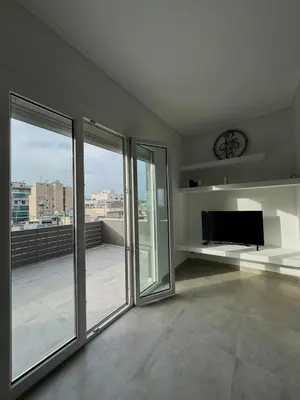 a living room with sliding glass doors and a flat screen tv at Captain's flat in Piraeus