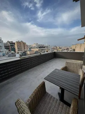 a patio with a table and chairs on a roof at Captain's flat in Piraeus