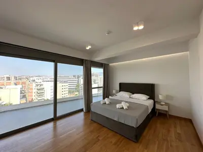 a bedroom with a bed and a large window at Niarchos Elegant Penthouse in Athens
