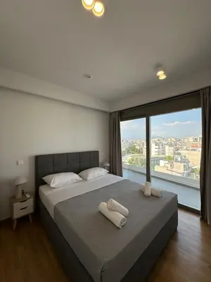 a bedroom with a large bed with a large window at Niarchos Elegant Penthouse in Athens