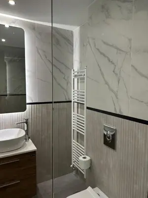a bathroom with a sink and a toilet and a mirror at Niarchos Elegant Penthouse in Athens