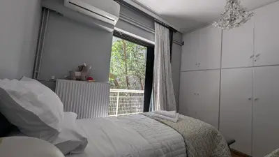 a bedroom with a bed and a large window at Maisonette Chalandri by DV10 Family House Luxury Oasis in Athens