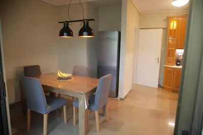 a dining room table with chairs and a refrigerator at Maisonette Chalandri by DV10 Family House Luxury Oasis in Athens