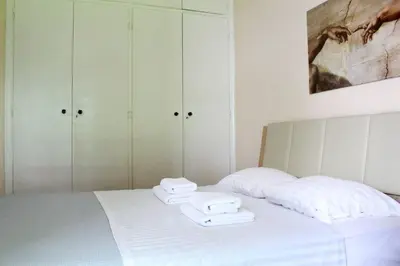a bedroom with a bed with white sheets and towels at Acropolis Cozy Apartment in Athens