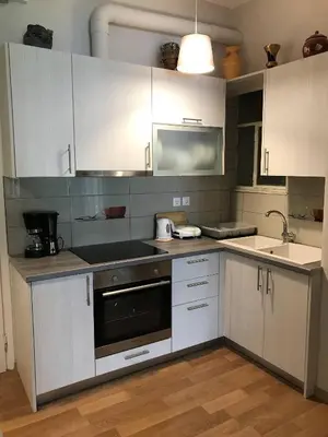 a kitchen with white cabinets and a sink at Acropolis Cozy Apartment in Athens