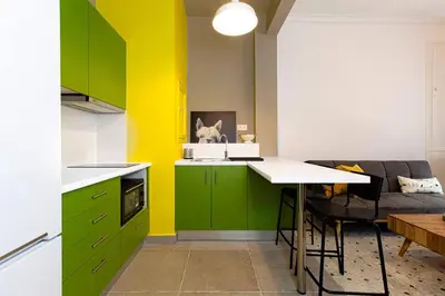 a kitchen with green cabinets and a yellow wall at Acropolis Lane in Athens