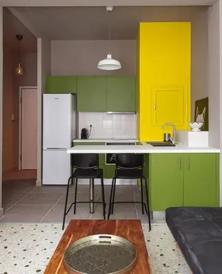 a kitchen with green and yellow cabinets and a table at Acropolis Lane in Athens