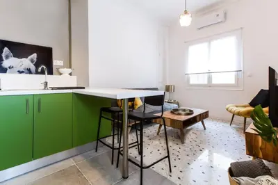 a kitchen with green cabinets and a table at Acropolis Lane in Athens