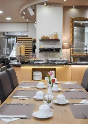 a table with plates and flowers in a kitchen at Acropolis Select in Athens