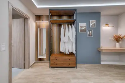 a room with a closet with white shirts and a mirror at The Garden of Eden Apartment in Piraeus