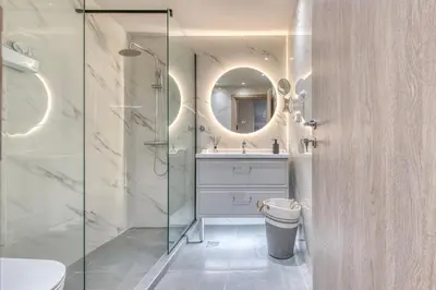 a bathroom with a shower and a sink and a mirror at The Garden of Eden Apartment in Piraeus