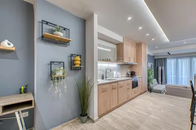 a kitchen with wooden cabinets and a dining room at The Garden of Eden Apartment in Piraeus
