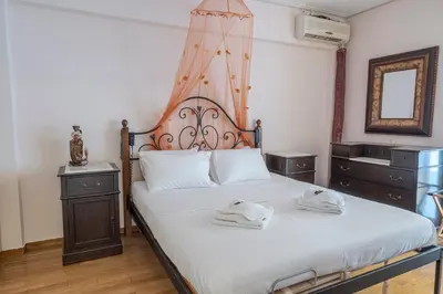 a bedroom with a bed with two towels on it at Comfortable Family Apartment,3 stops to Acropolis in Athens