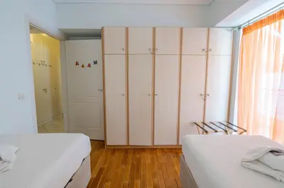 a bedroom with two beds and a closet at Comfortable Family Apartment,3 stops to Acropolis in Athens