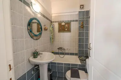 a bathroom with a sink and a tub and a toilet at Comfortable Family Apartment,3 stops to Acropolis in Athens
