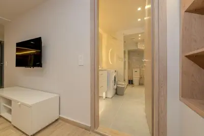 a white bathroom with a toilet and a mirror at Pythagorio Apartment in Piraeus