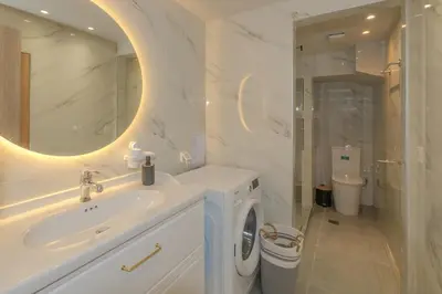a bathroom with a sink and a washing machine at Pythagorio Apartment in Piraeus