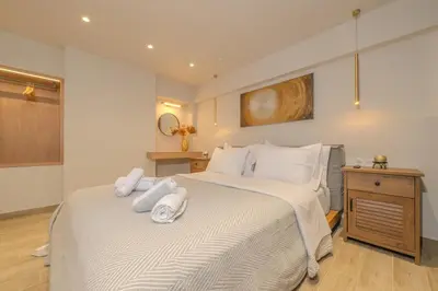 a bedroom with a large bed with towels on it at Pythagorio Apartment in Piraeus