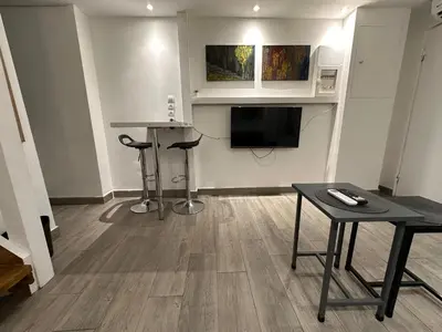 a living room with a television and a table at Ground floor next to Errikos Ntinan and Erithros in Athens
