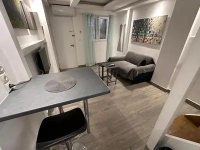 a living room with a table and a couch at Ground floor next to Errikos Ntinan and Erithros in Athens