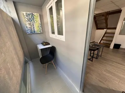 a hallway with a chair and a table and stairs at Ground floor next to Errikos Ntinan and Erithros in Athens
