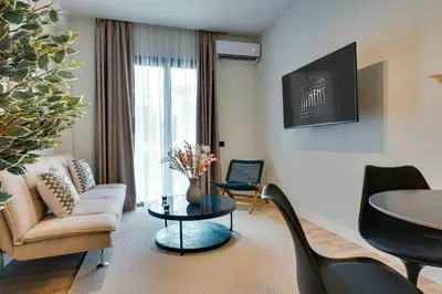 a living room with a couch and a table and chairs at Skyline Spa Athens 110 in Athens