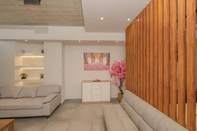 a living room with a couch and a vase of flowers at Pink Season Apartment in Piraeus