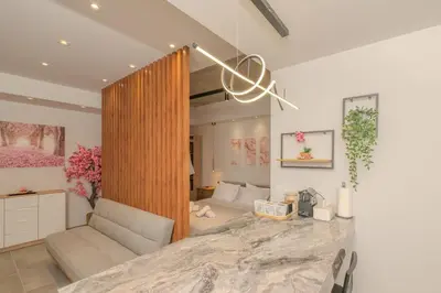a living room with a couch and a table in a room at Pink Season Apartment in Piraeus