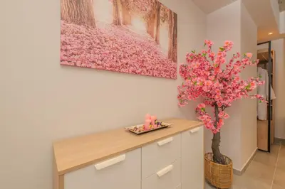 a room with a table and a tree with pink flowers at Pink Season Apartment in Piraeus