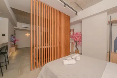 a bedroom with a bed with two towels on it at Pink Season Apartment in Piraeus