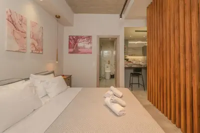 a bedroom with a bed with two towels on it at Pink Season Apartment in Piraeus