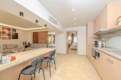 a kitchen and living room with a counter and chairs at Fairytale Apartment in Piraeus