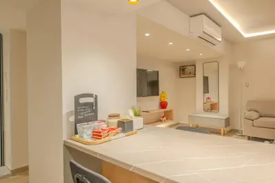 a kitchen with a counter top and a living room at Fairytale Apartment in Piraeus