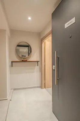a hallway with a door and a mirror at Fairytale Apartment in Piraeus