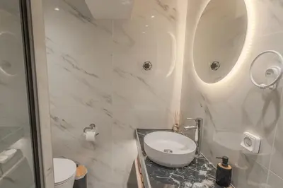 a white bathroom with a sink and a toilet at Fairytale Apartment in Piraeus