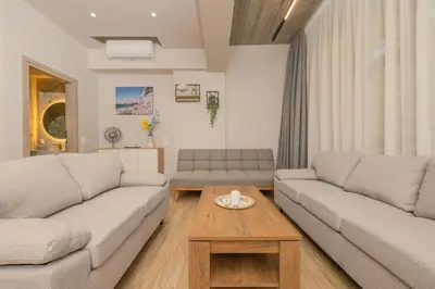 a living room with two couches and a coffee table at Saint Mykonos Apartment in Piraeus