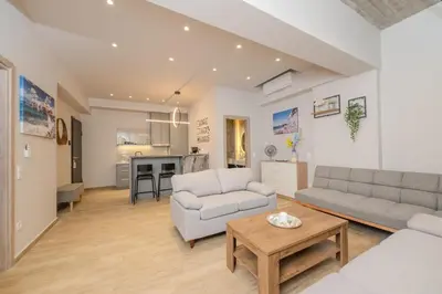 a living room with two couches and a table at Saint Mykonos Apartment in Piraeus