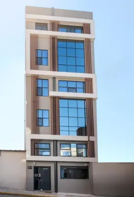 a building with many windows on the side of it at Saint Mykonos Apartment in Piraeus