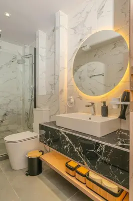 a bathroom with a sink and a mirror and a toilet at Saint Mykonos Apartment in Piraeus