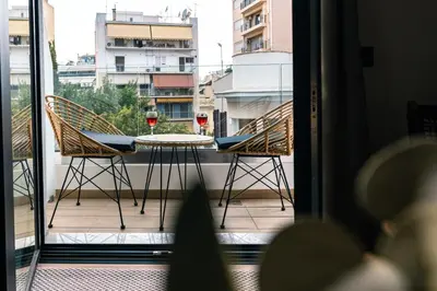 a balcony with a table with two glasses of wine at Skyline Spa Athens 210 in Athens